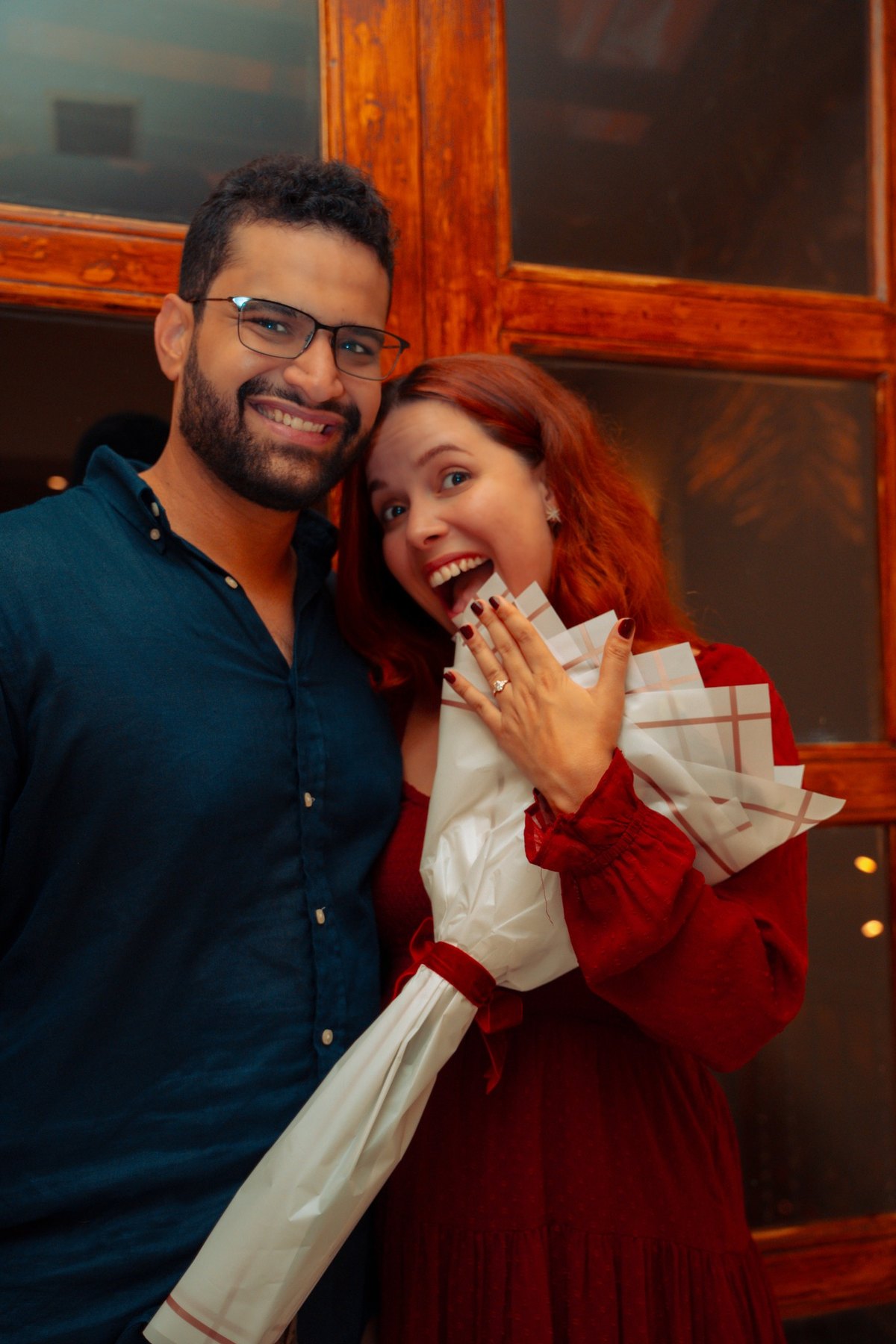 Couple celebrating and showing the engagement ring