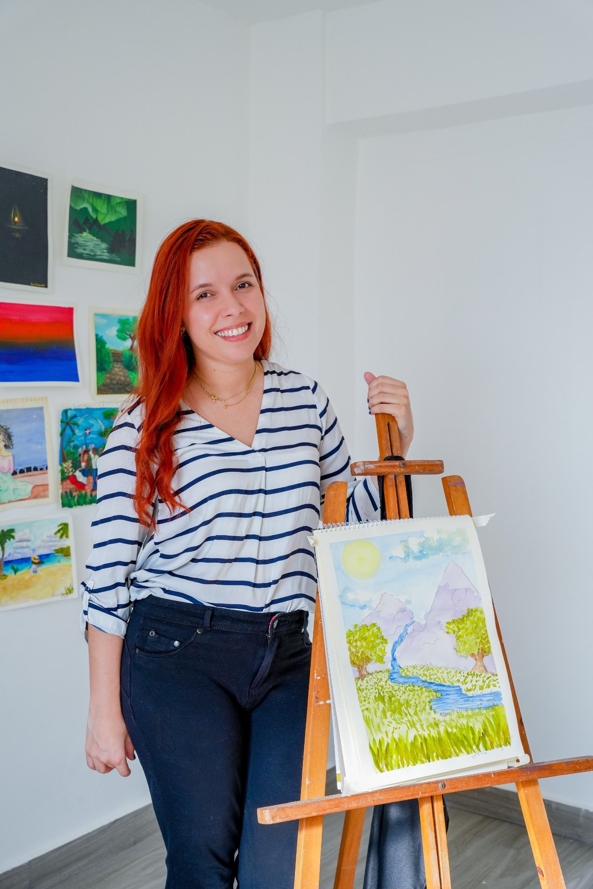 Artista junto a su pintura en acuarela