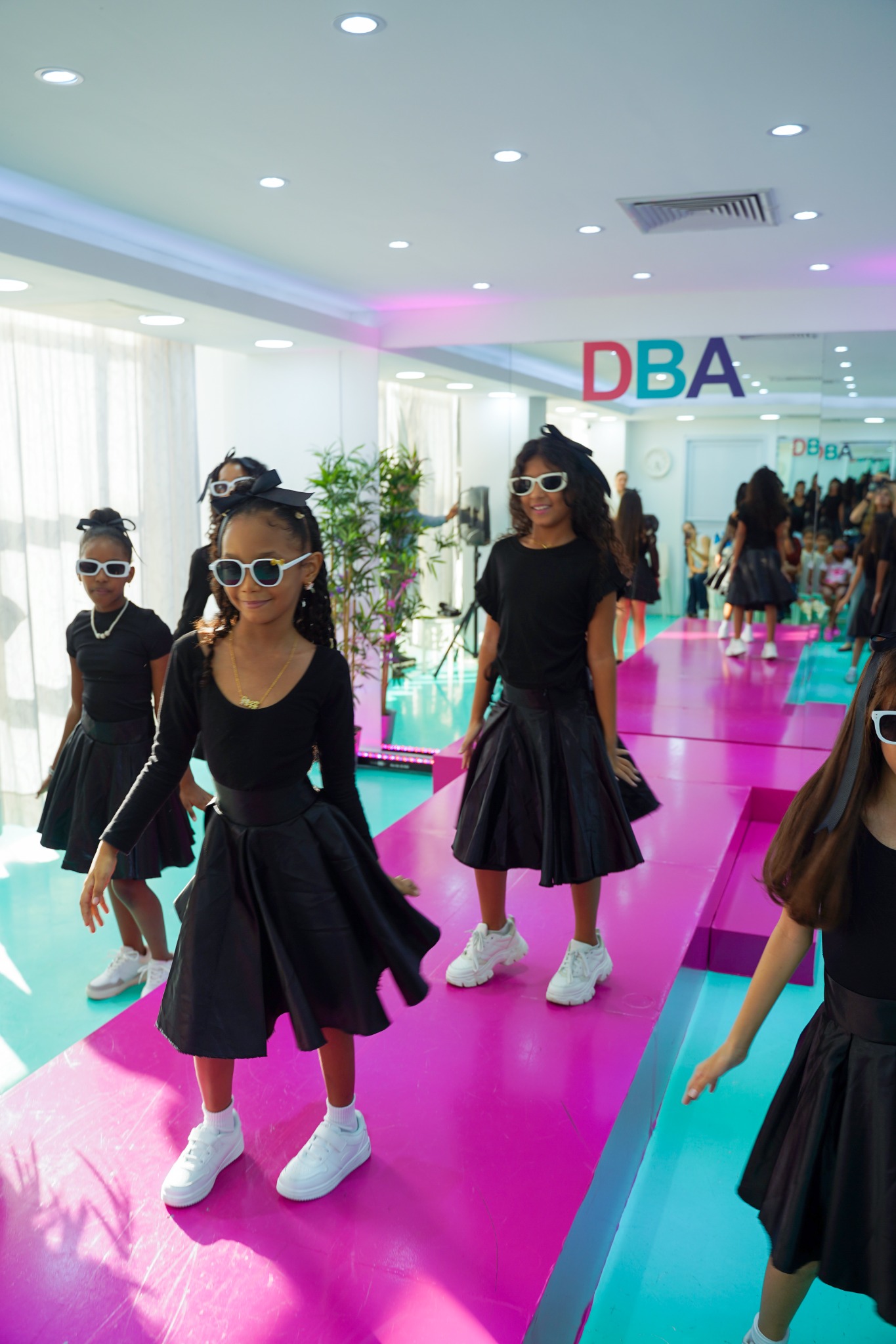 Grupo de jóvenes modelos avanzando por una pasarela colorida