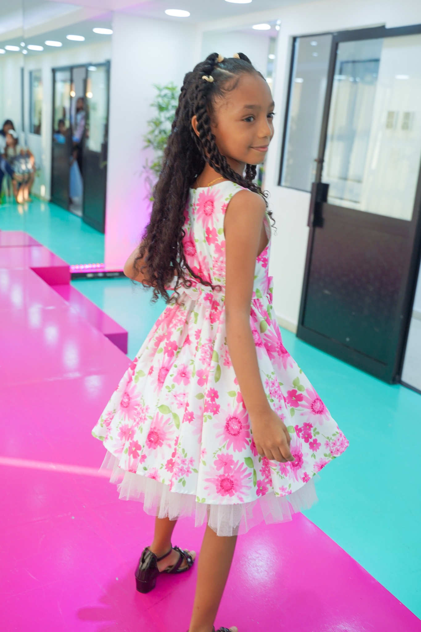 Niña mostrando el movimiento de su vestido sobre la pasarela